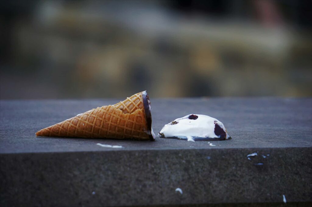 A picture of an ice cream cone that has been dropped on the ground