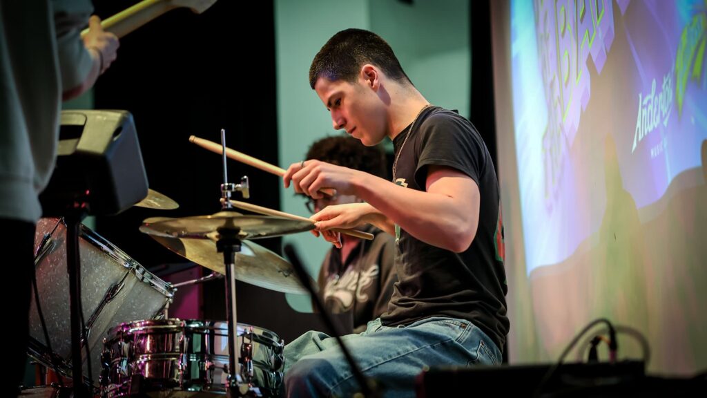 Cool Young Male Drummer Focusing While Performing Live